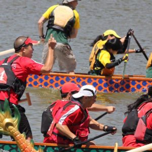 people rowing and racing dragonboats on water